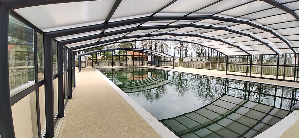 abri en verre pour la piscine xxl d'un camping situé en Vendée