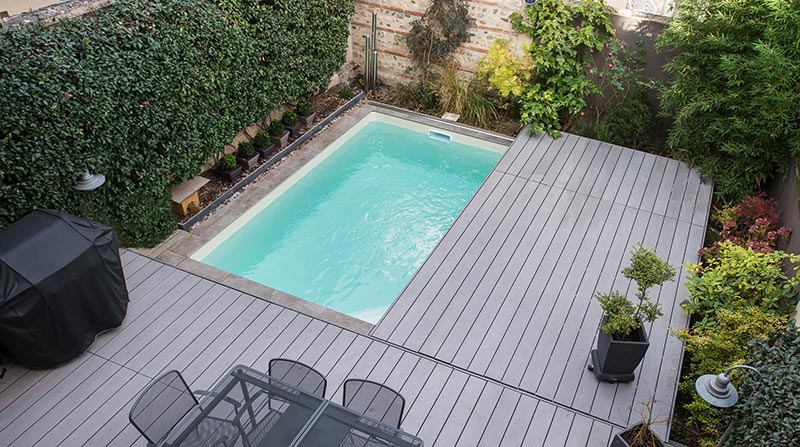 Vue de haut d'une terrasse mobile de piscine revêtement composite dans un petit jardin