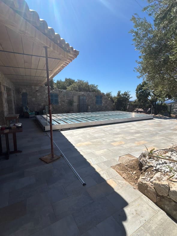 Structure aluuminium de la terrasse mobile sur la piscine de cette maison corse