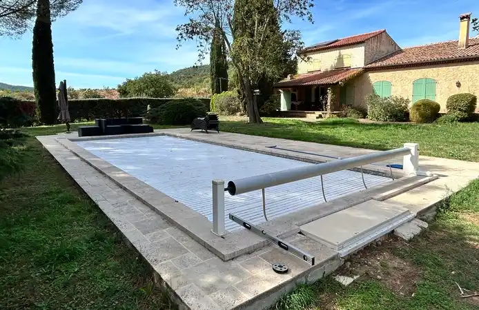 Espace piscine avant la mise en place de la terrasse mobile et de la pergola. La piscine est couverte par un rideau roulant
